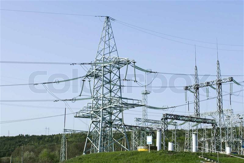 Towers of high voltage transmission lines and other electrical engineering equipment, stock photo