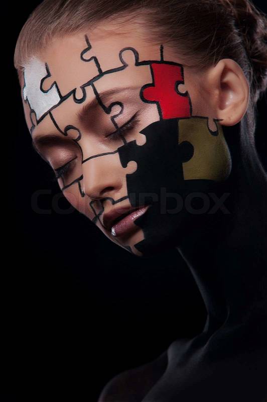 Puzzles painted on a beautiful woman\'s face, stock photo
