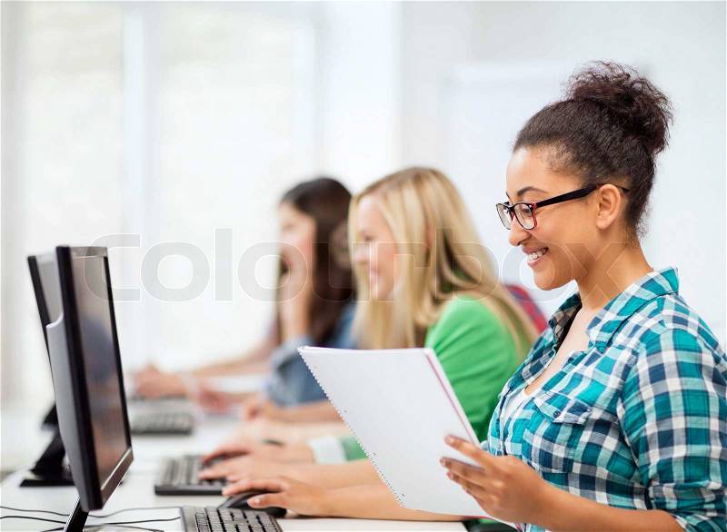 Education concept - african student with computer studying at school, stock photo