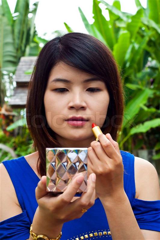 Beautiful Asian woman making up, stock photo