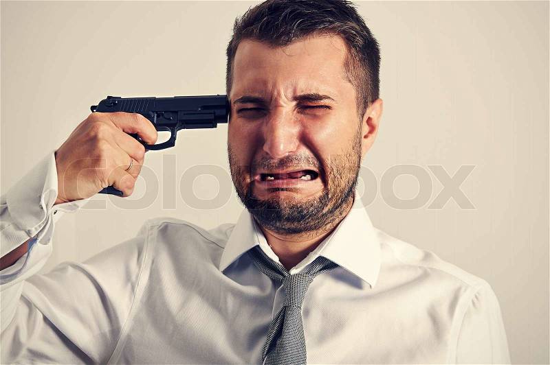 Businessman with gun wants to commit suicide, stock photo
