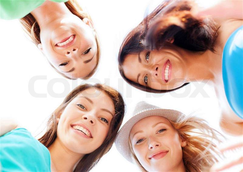 Summer holidays and vacation concept - faces of girls looking down and smiling, stock photo