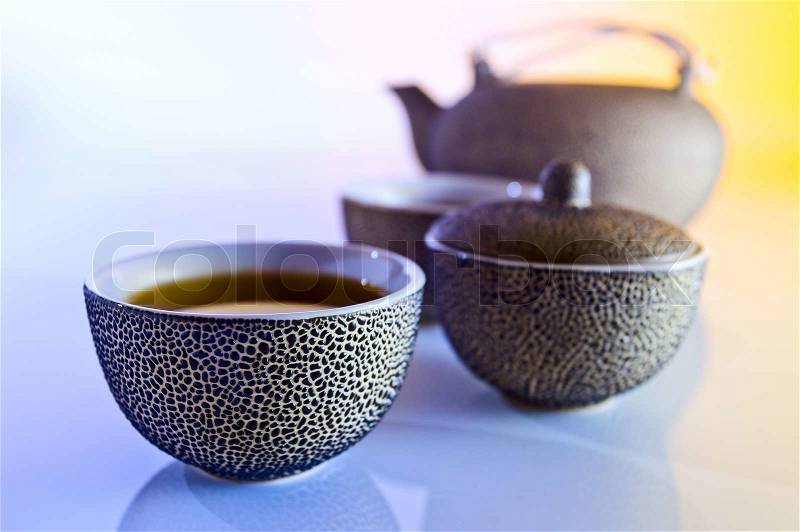 tea in small Japanese cups on a reflective background, stock photo
