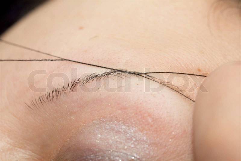 Plucking eyebrows thread, stock photo