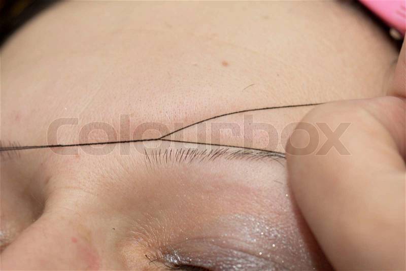 Plucking eyebrows thread, stock photo