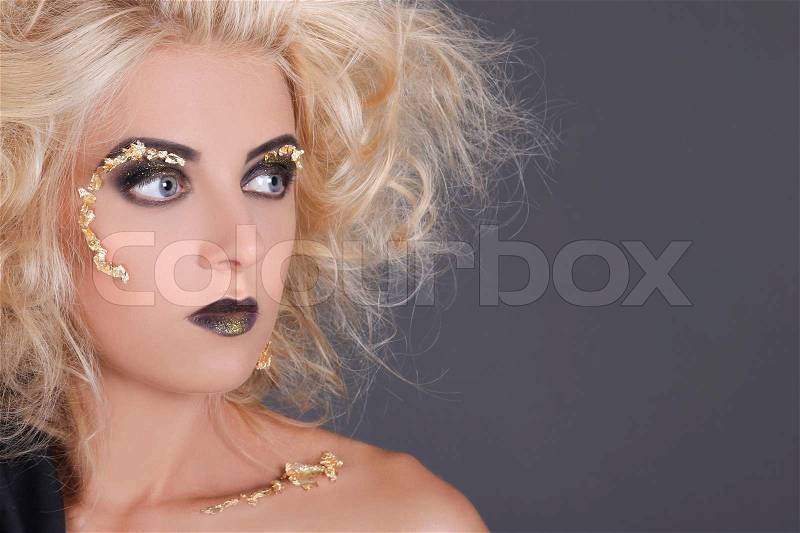 Close up portrait of blondie witch over gray background, stock photo