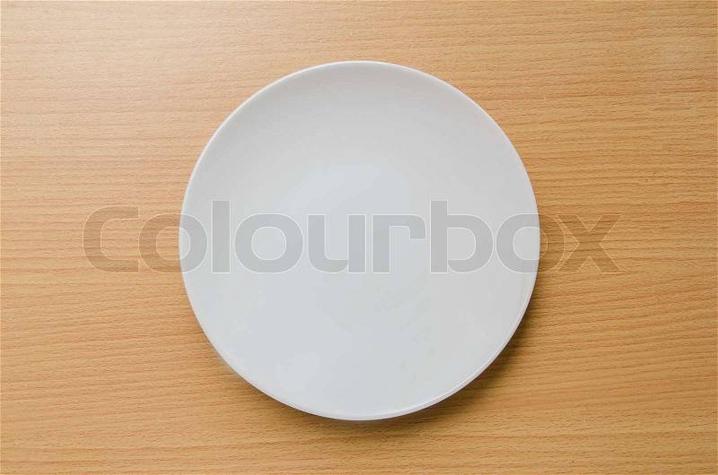 Empty white plate on wooden, stock photo