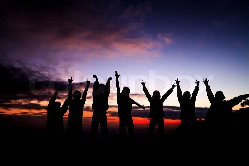 Silhouette of group of friends standing in sunset, stock photo