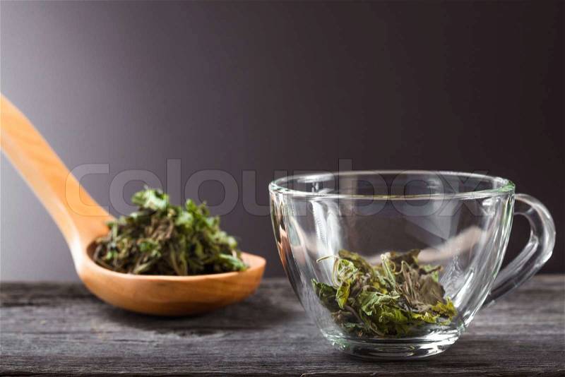 Cup of green mint tea and spoon with dry mint, stock photo