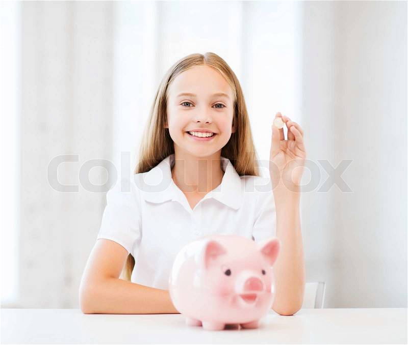 Education, school and money saving concept - child putting coins into piggy bank, stock photo