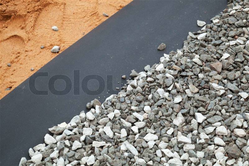 Geotextile layer between gravel and sandy ground, stock photo