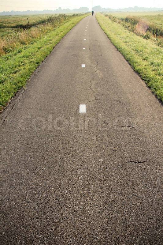 Bike path with lines and in the distance the small village at the country side, stock photo