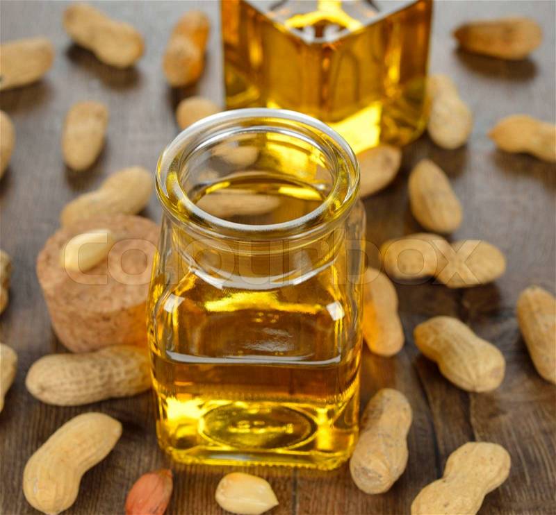 Peanut oil in a glass bottle on a brown background, stock photo