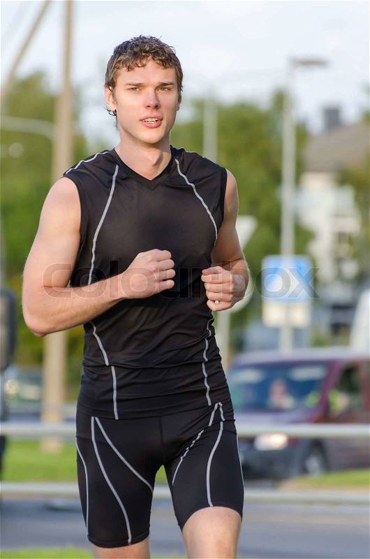 Young handsome sportsman running on the street, stock photo