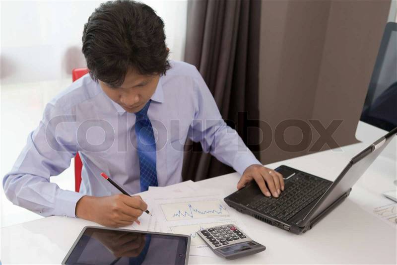 Asian businessman busy working in his room, stock photo