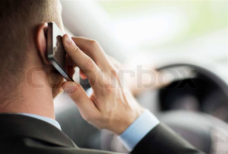 Transportation and vehicle concept - man using phone while driving the car, stock photo