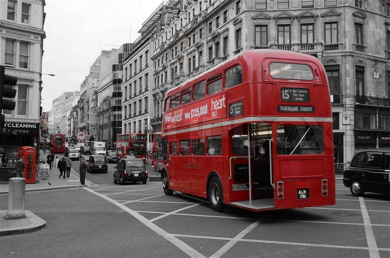 A vintage red London bus and black taxis in the streets, stock photo