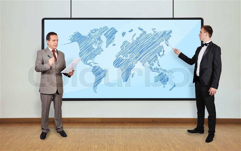 Two businessman in office and world map on plasma panel, stock photo