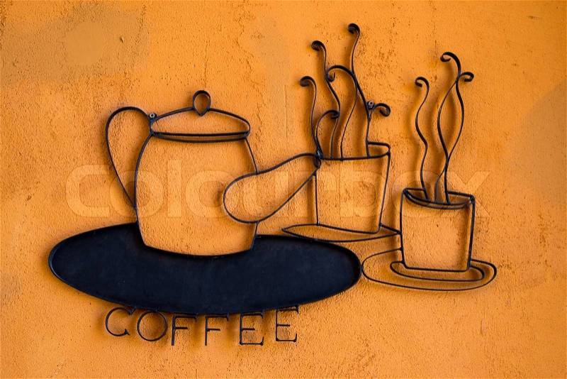 Coffee wrought iron on orange wall, stock photo