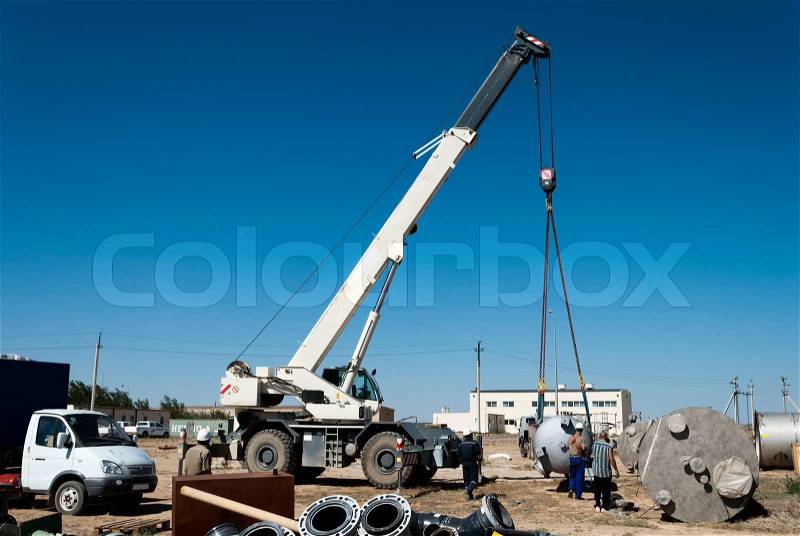 Industrial area. Unloading by the crane of the production equipment, stock photo