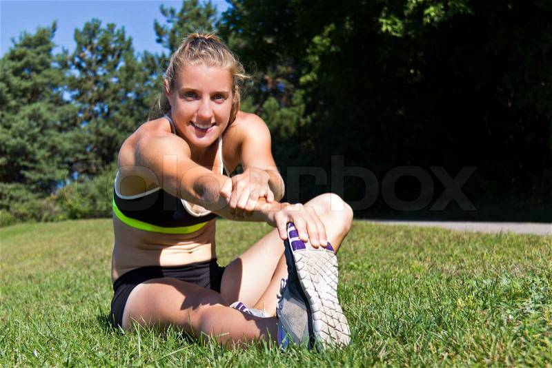 Fit woman stretching her muscles before running, stock photo