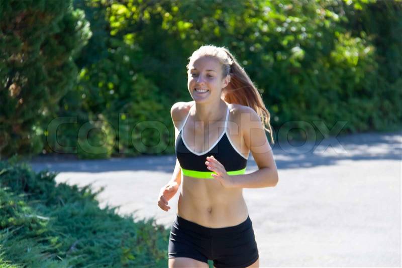 Young fit woman running for fitness, stock photo