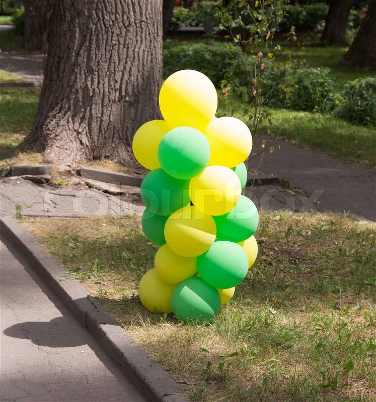 Yellow and green balloons in nature, stock photo