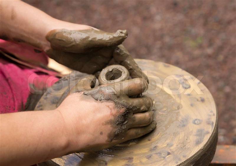 Potter hands making in clay on pottery wheel. Potter makes on the pottery wheel clay pot, stock photo