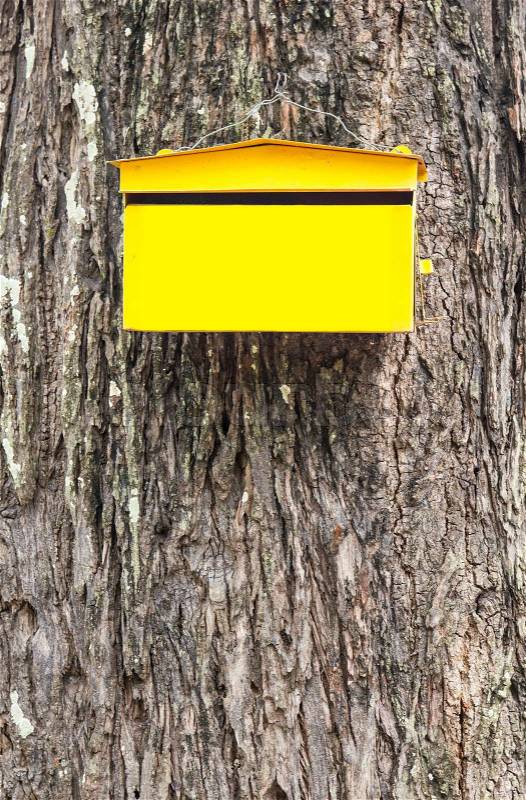 Yellow post box mailbox on skin tree background, stock photo