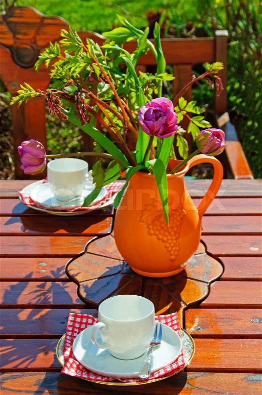 Table in garden with coffee cups, stock photo