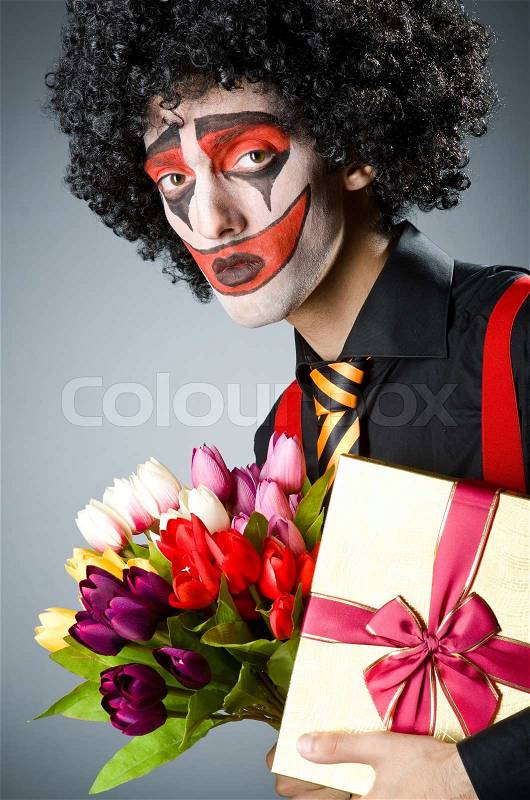 Sad clown with the flowers, stock photo