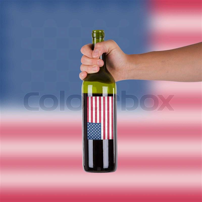 Hand holding a bottle of red wine, label of the United States, isolated on white,, stock photo