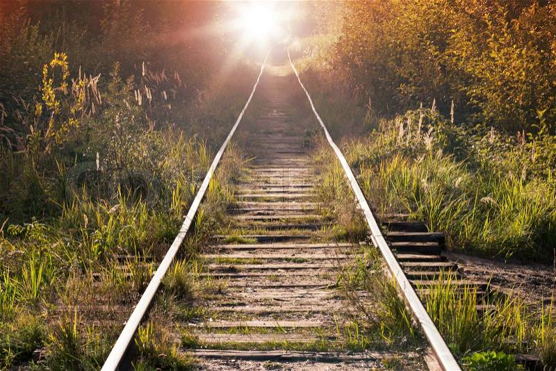 Summer rural railway perspective with shining sun in the end, stock photo