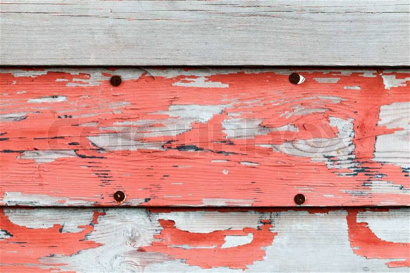 Old obsolete advertisement wooden wall with red paint and rusted pushpins, stock photo
