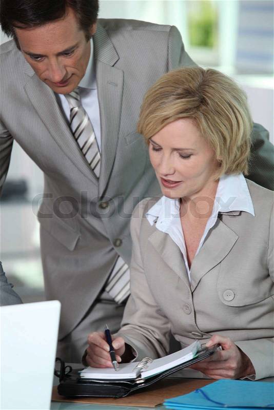 Business couple putting a date in the diary, stock photo
