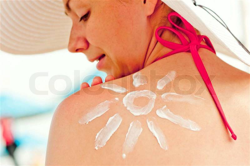 Drawn sun sun cream on his shoulder a beautiful young woman, stock photo