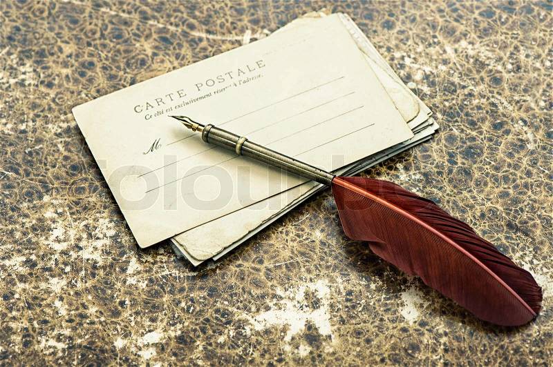 Nostalgic retro style background with old postcards and antique ink feather pen, stock photo