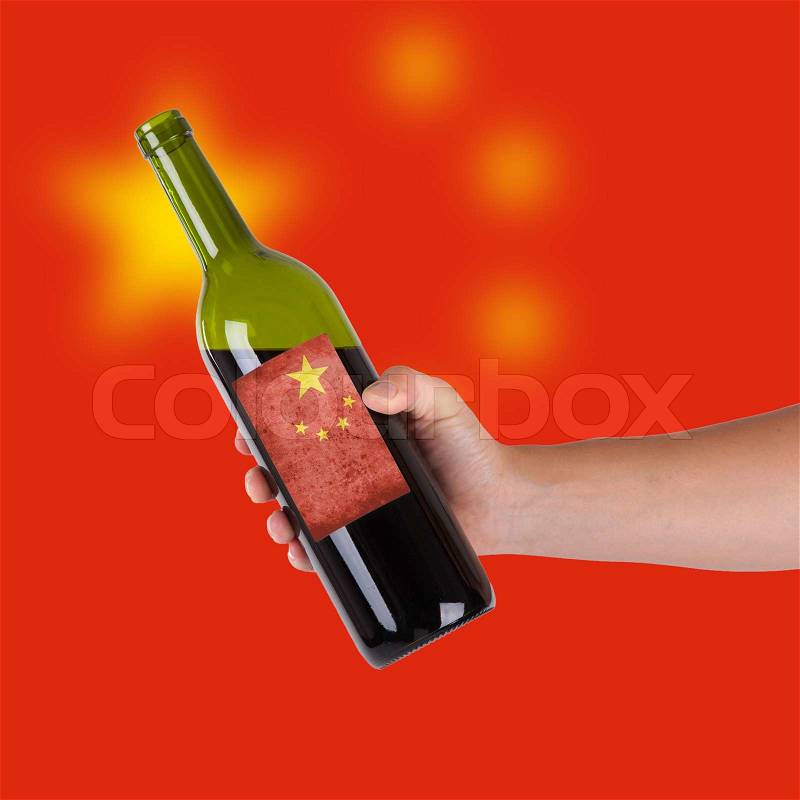 Hand holding a bottle of red wine, label of China, isolated on white,, stock photo