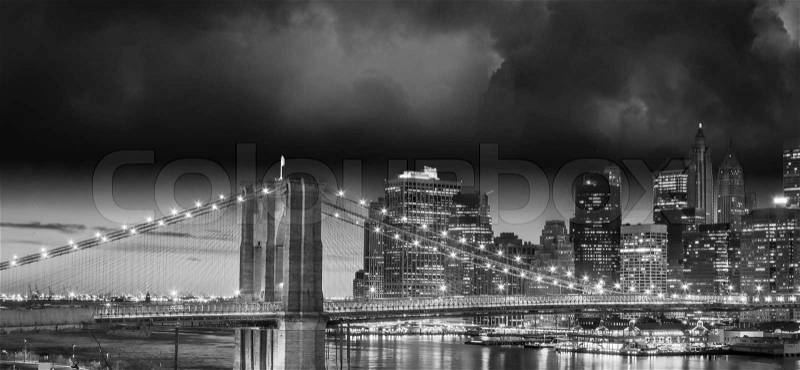 New York City Manhattan skyline and Brooklyn Bridge at dusk over East River with skyscrapers, stock photo