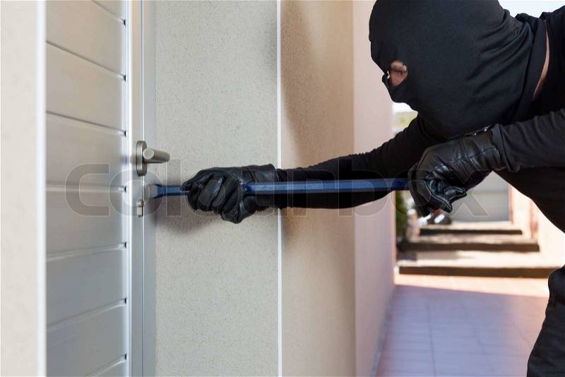 Thief with a bar of iron in the hand to open a door, stock photo