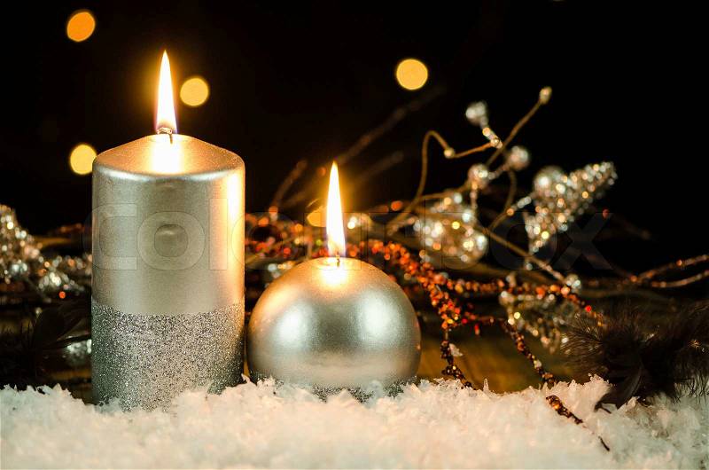 Silver christmas decoration on snow against dark background, stock photo