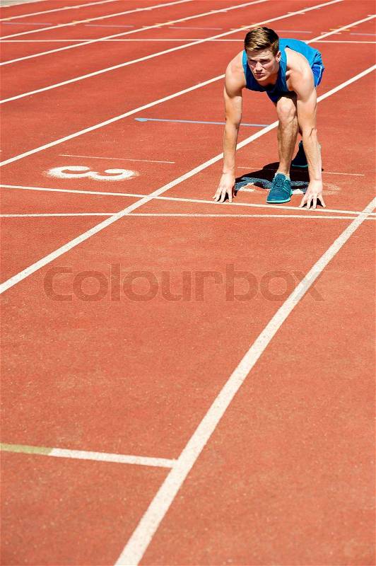 Fit male athlete on second running track, stock photo
