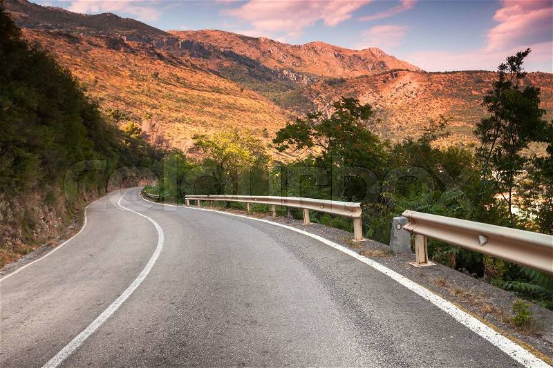 Curved mountain highway in soft early morning sun light, stock photo