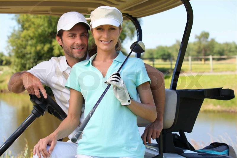 Couple in golf car, stock photo
