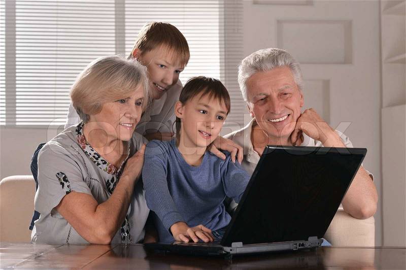Happy family at a laptop in the room, stock photo