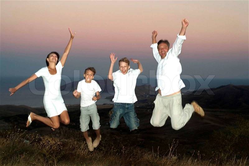 Beautiful family jumping on the nature of the evening, stock photo