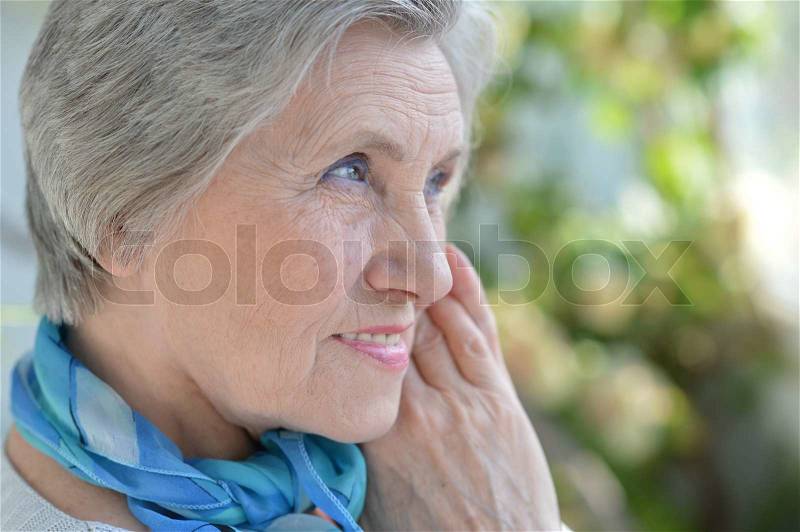 Portrait of an aged woman with a blue neck scarf home, stock photo