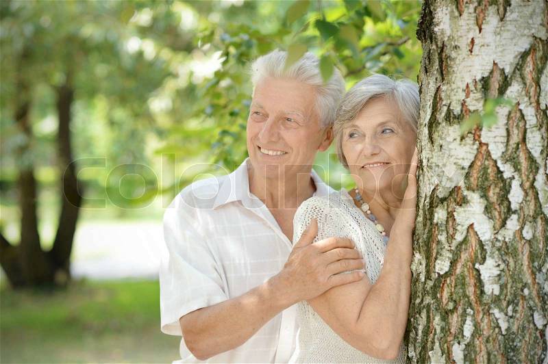 Old couple in love walking in the park in spring, stock photo