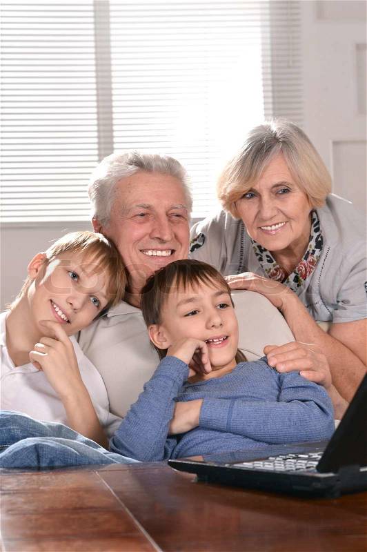 Two boys and grandparents with a laptop, stock photo