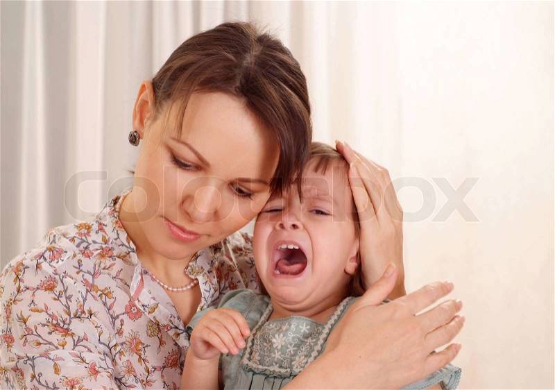 Mother calming her crying little daughter, stock photo